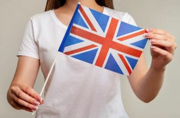 Woman in white shirt holding union jack flag