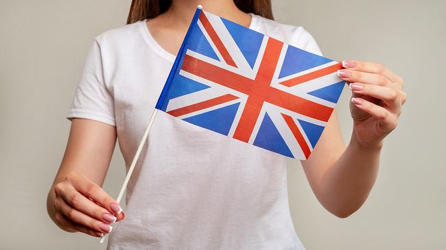 Woman in white shirt holding union jack flag